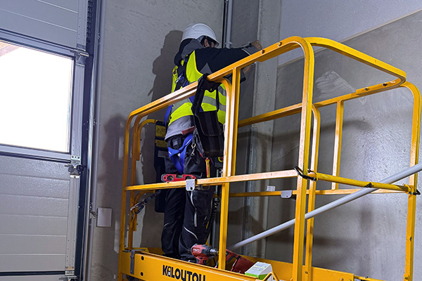 Techniker der G&N Gruppe installiert in einer Lagerhalle in Hamburg einen Bewegungsmelder